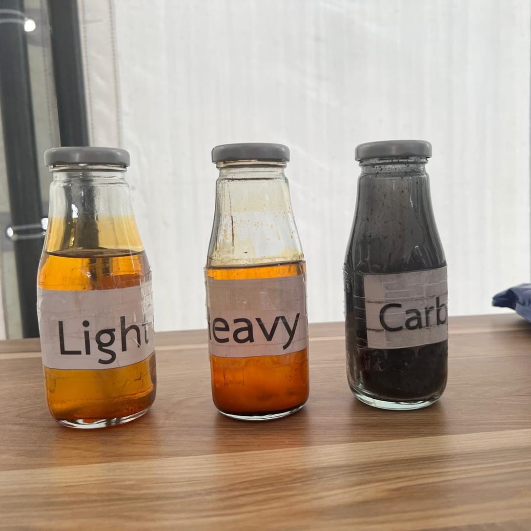 Tre campioni in barattolo dei prodotti della pirolisi: olio leggero, olio pesante e carbon black.