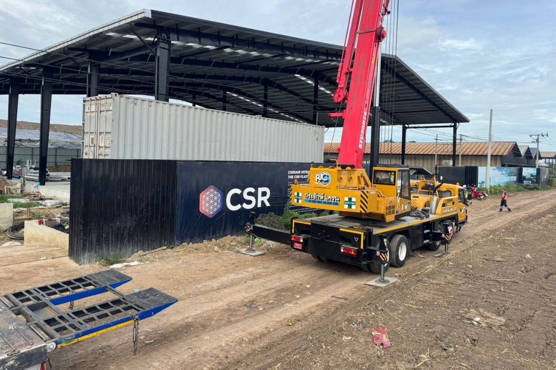 Gru e container nel cantiere dell’hangar dell’impianto Corsair Bangkok, con la recinzione marchiata CSR.